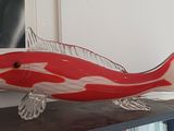 une sculpture représentant un poisson rouge et blanc posée sur une table