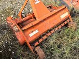 an orange lawn mower that is laying in the grass
