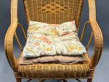 une chaise en osier sur laquelle sont posés deux coussins
