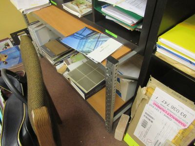 une guitare posée sur un bureau devant une bibliothèque