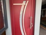 une porte rouge ornée d'un motif argenté