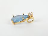 a close up of a gold ring with a blue topaz stone