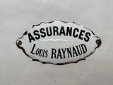 une pancarte portant l'inscription « Assurances Louis Raynaud » sur le flanc d'un bus