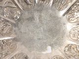 a silver plate with designs on it in the middle of a room