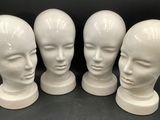 quatre têtes de mannequins blanches sont alignées en rang
