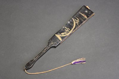 un peigne à cheveux noir et doré orné d'une fleur violette