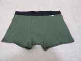 men ' s green boxers with black waistbands laying on a bed