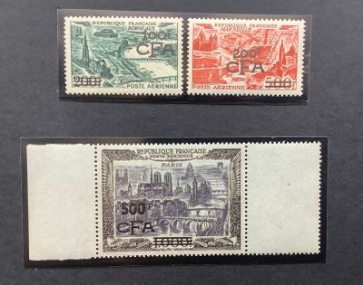 two stamps with a picture of a city on them on a black surface