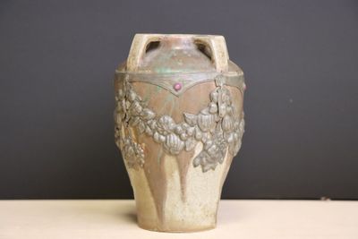 a vase that is sitting on a table in front of a wall