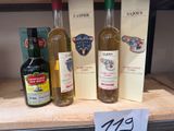 trois bouteilles de vin et une bouteille d'alcool sur une étagère