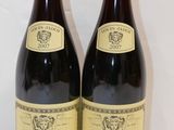 deux bouteilles de vin posées sur une table l'une à côté de l'autre