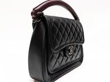 a close up of a black handbag on a white background