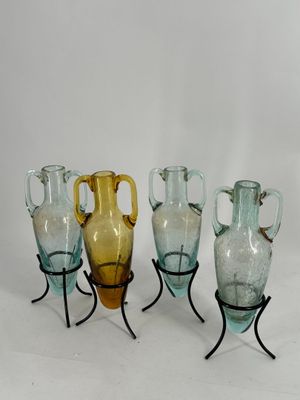 cinq vases en verre posés sur un support en métal