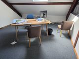 un bureau avec deux chaises et un ordinateur posé dessus, dans une pièce
