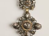 une image montrant un gros plan d'un collier orné d'une horloge