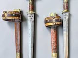 three different types of swords are displayed on a white surface