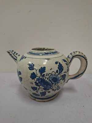 a blue and white teapot on a white table