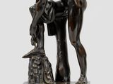 an image of a bronze statue of a man bending over a rock