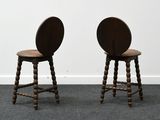 two wooden stools sitting on top of a carpeted floor next to a white wall