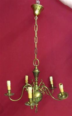 an image of a brass chandelier hanging from a red wall
