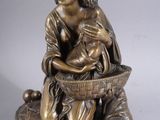 bronze figurine of a woman with a basket of fruit