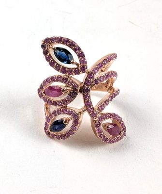 une photo en gros plan d'une bague sertie de pierres violettes et bleues