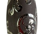 un vase noir orné d'un motif sur fond blanc