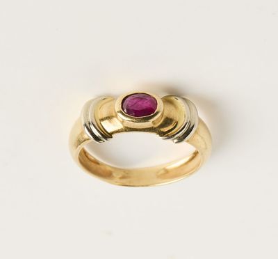 gros plan d'une bague en or avec une pierre en rubis