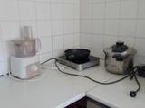 a small kitchen with a stove, microwave, toaster, and other appliances