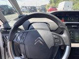 a steering wheel and dashboard of a car in a parking lot