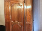 a wooden armoire in the corner of a room