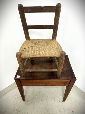 a wooden chair that has a woven seat on it