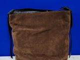 un sac en papier brun posé sur une table blanche, près d'un mur bleu