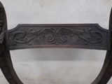 carvings on the back of a wooden bench against a white wall