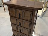 une petite commode en bois exposée dans une pièce
