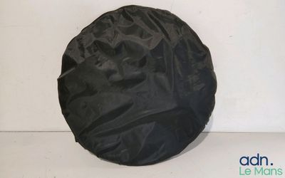 un gros plan d'une housse de pneu noire posée sur une surface blanche