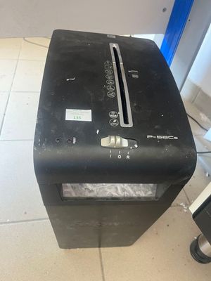 une déchiqueteuse à papier noire posée par terre à côté d'un ordinateur