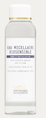 un gros plan d'une bouteille contenant un liquide posée sur une surface blanche