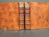 two old books sitting on top of each other on a table