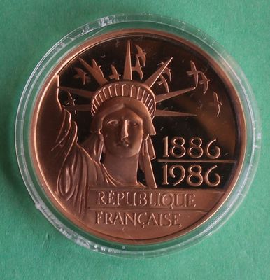 a close up of a coin with a statue of liberty on it