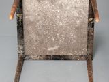 an old wooden chair with a metal frame on a gray background