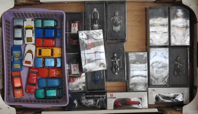 une valise violette remplie de jouets divers et d'autres objets