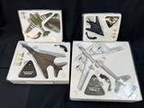 trois boîtes contenant un assortiment de maquettes d'avions, posées sur une surface noire
