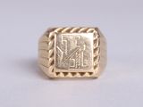 a close up of a gold signet ring on a white surface