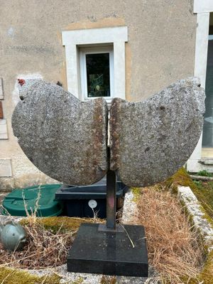 a stone sculpture of a bird sitting on top of a rock