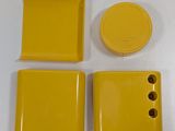 four pieces of yellow plastic on a white surface