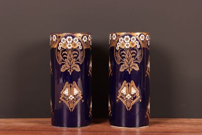 une paire de vases bleus et dorés posés sur une table en bois