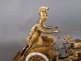 a gold statue of a woman pulling a carriage with a horse