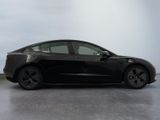 the black tesla model 3 is parked in the garage