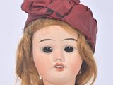 a close up of a doll with a red hat on